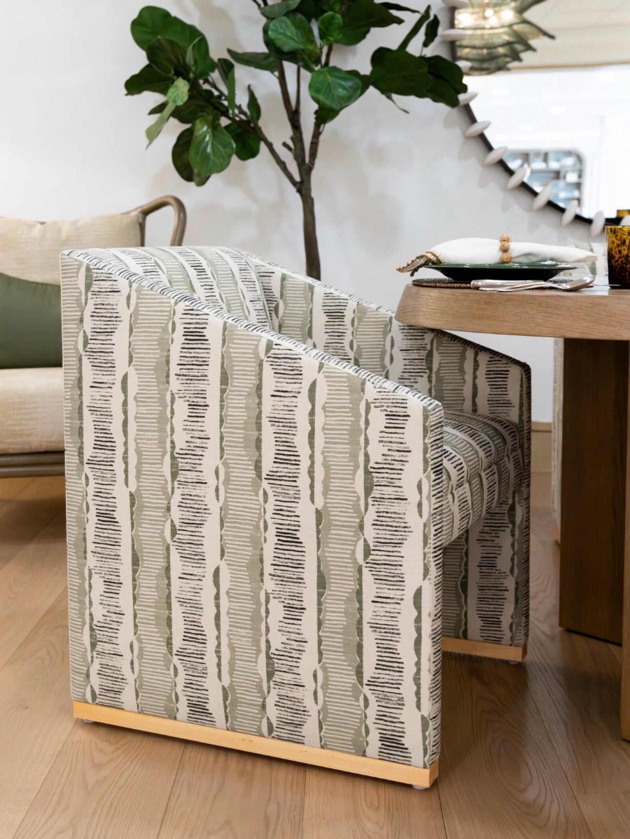 Modern Dune Dining Chair beside a potted plant and dining table set in a contemporary living space, exuding easygoing elegance with a touch of modern organic style.