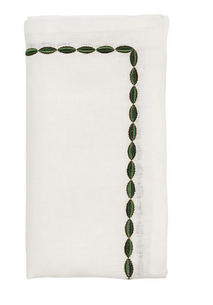The Kim Seybert Swag Napkin Set features white linen napkins with green oval embroidery along two edges, ideal for elegant table settings.