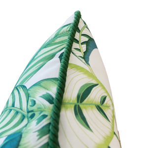Close-up of a 22" x 22" Calathea Green Outdoor Pillow featuring a green leaf pattern and green twisted cord trim along the edge. This custom-made pillow adds a fresh, vibrant touch to any space.