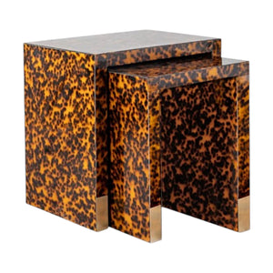 The Raleigh Nesting Table showcases two square shapes with a tortoise finish and brass accents at the base, all set against a white background.