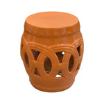 The Rusty Orange Fine Porcelain Circle Stool features circular cutout patterns on the sides and a solid flat top, inspired by classic garden stools and crafted with quality porcelain for lasting beauty.