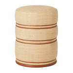 The Quinn Stool in Natural/Saddle is a round, beige woven raffia ottoman featuring two horizontal brown bands and a brown base, handcrafted and shown against a white background.