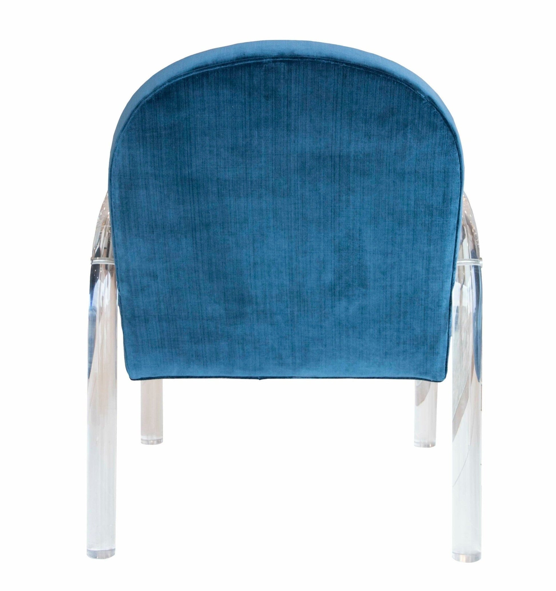 The Elva Acrylic Arm Chair features a blue upholstered seat with a rounded backrest, transparent legs, and elegant acrylic arms, viewed from behind.