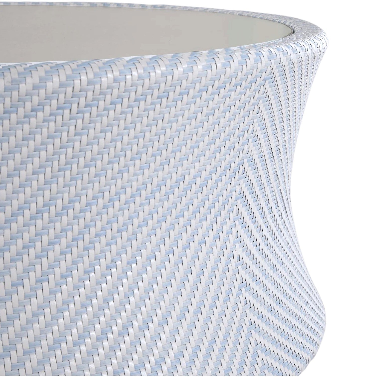Close-up of the Bari Round Coffee Table in Chambray, featuring a light blue and white woven chevron pattern, slightly flared rim, and resin wicker appearance.