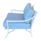 Side view of the Haret Outdoor Lounge Chair with light blue cushions, white piping, a white metal frame, and signature fretwork on the back and seat.