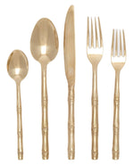 A set of five gold-colored utensils with bamboo-style handles, perfect for a sophisticated table, includes a tablespoon, a teaspoon, a knife, a dinner fork, and a salad fork. This is the Blue Pheasant Liliana Bamboo 5 Piece Flatware Set in Polished Gold.