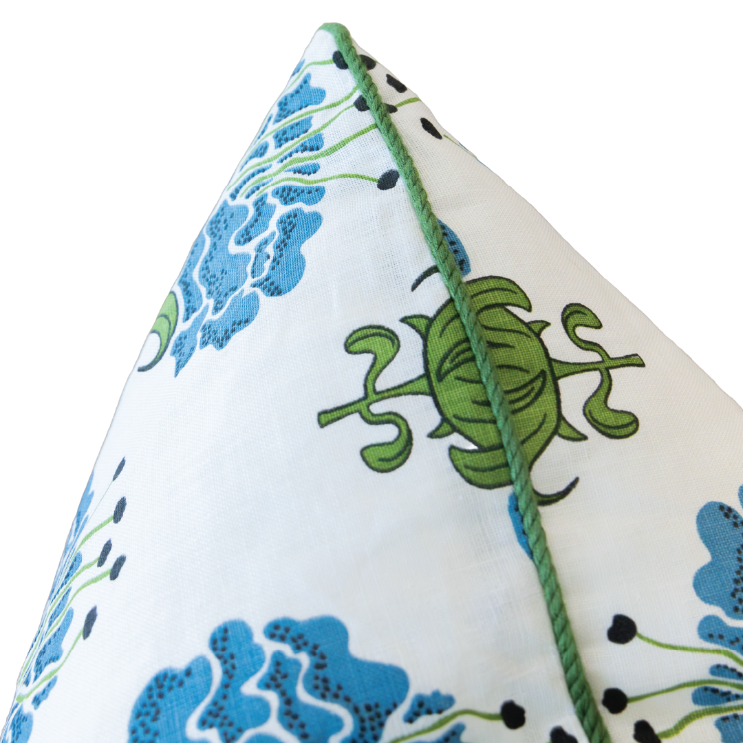 Close-up of the Peony Bluebell Lumbar Pillow, showcasing its white fabric adorned with blue floral patterns and a green turtle design, finished with green piping along the edge and a hidden zipper closure for a seamless look.