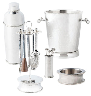 A Juliska Graham Barware Collection featuring modern silhouettes includes a cocktail shaker, ice bucket, various utensils on a stand, and a smaller container—all boasting a gleaming mirror polish.