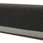 A rectangular, dark gray Harlow Bench with maze tape trim at the base, resting on a wooden frame.