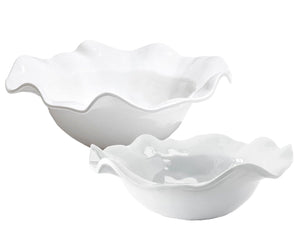 Against a pristine backdrop, two white ceramic bowls with wavy edges in varying sizes exemplify the elegance of the Beatriz Ball VIDA Havana Serveware Collection. Perfect for indoor and outdoor gatherings, these sophisticated pieces enhance any setting with their subtle luxury.