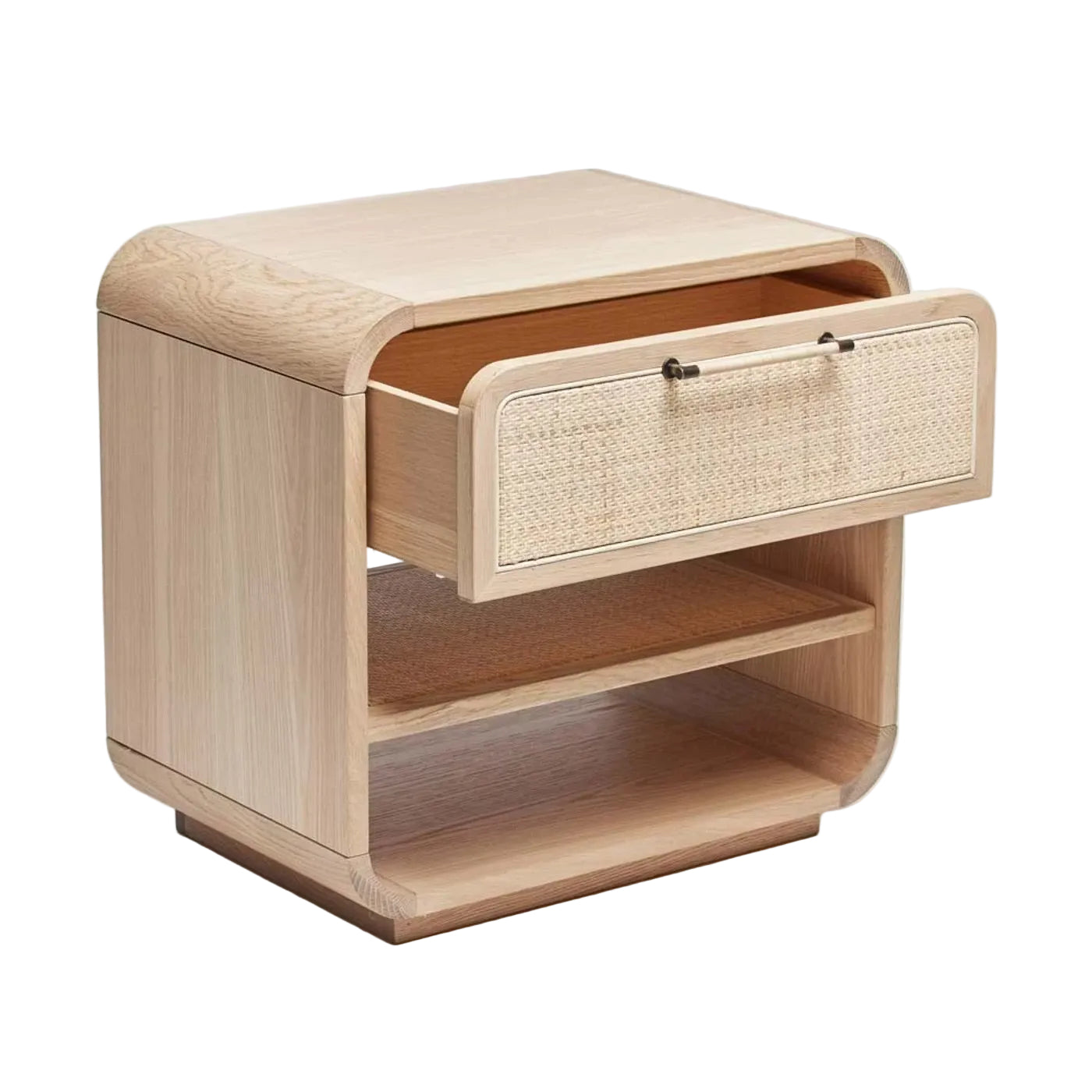 The Marsh Bedside Chest is a light wood bedside chest with rounded edges, an open lower shelf, and a single upper drawer featuring a blonde rattan front and two handles.