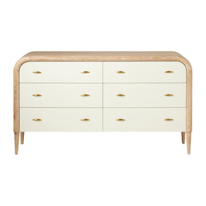 The Pierre Dresser in Pristine Shagreen and Washed Oak features six drawers, a rounded frame, white fronts, gold handles, tapered legs, and a light wood finish.