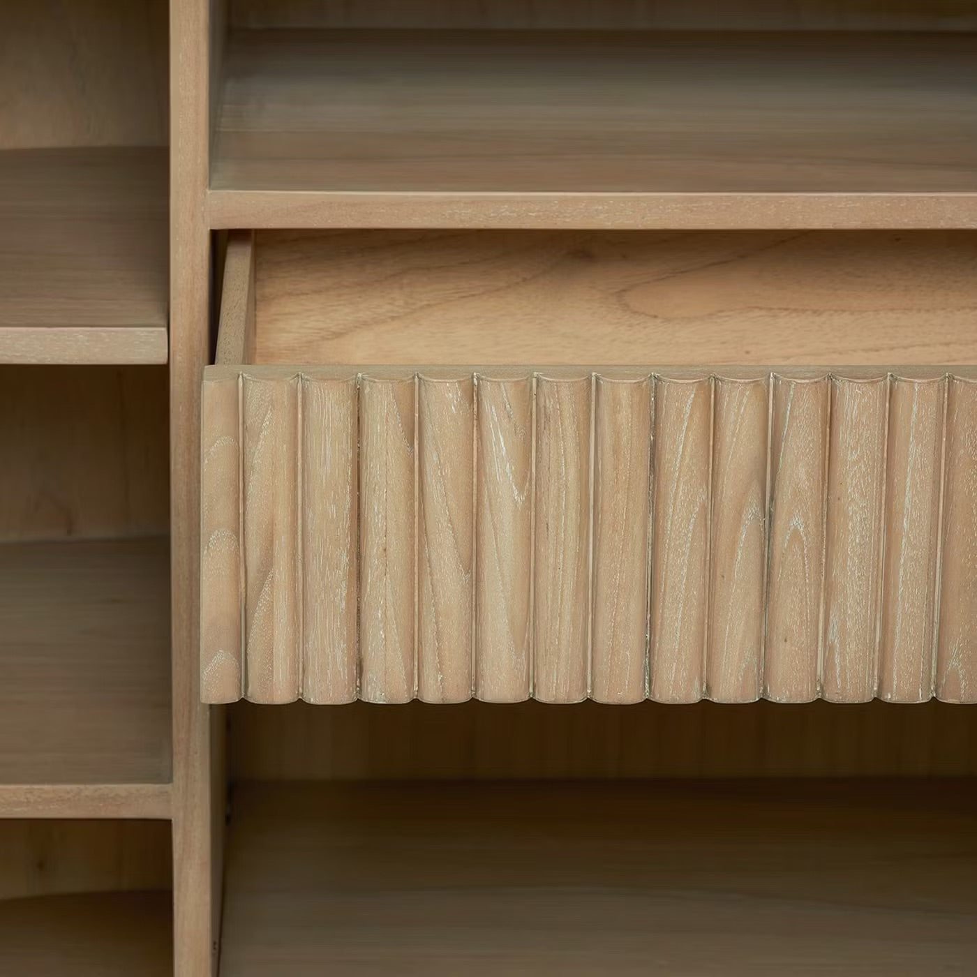 Close-up of the Anton Bar drawer featuring a grooved vertical design, highlighted natural wood grain, and surrounded by shelves for smart storage solutions.