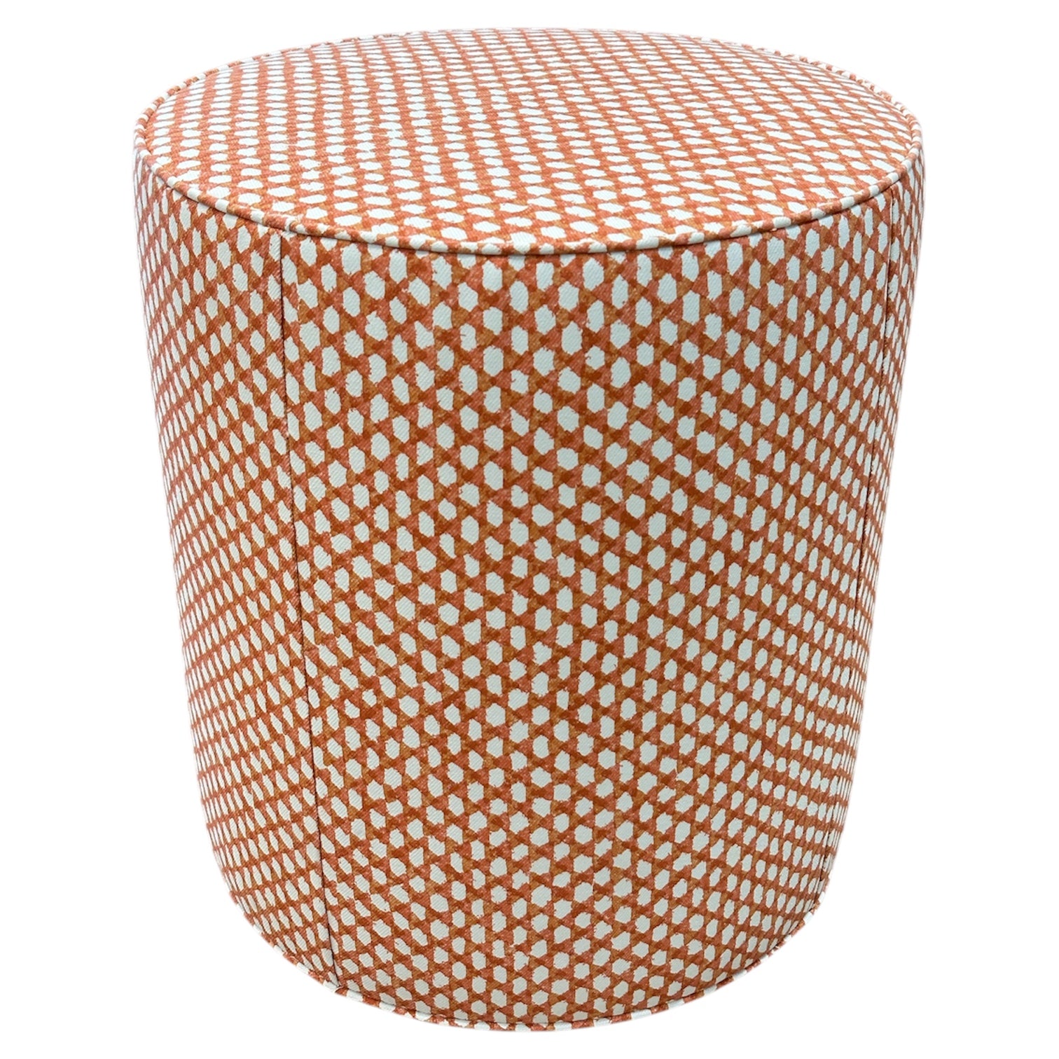 The Outdoor Drum Ottoman in Wicker Outwick Mandarin features cylindrical design and orange-white geometric upholstery, making it a vibrant addition to your outdoor space.