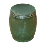 The Olive Green Cylinder Stool is crafted from quality porcelain with a glossy finish, featuring a rounded shape and subtle horizontal lines near the base, shown against a white background.