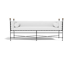 The Amalfi Tuxedo 3 Seat Sofa features cylindrical bolster pillows, a slim black metal frame with gold corner accents, and hand-forged latticework, all presented in a modern white design against a white background.