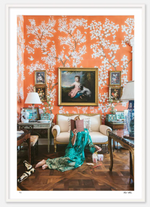 Person in a green dress sits on the floor of a lavishly decorated room with orange floral wallpaper, reading Nick Mele Fine Art Chinoiserie. A dog lies on the floor nearby. A painting of a woman hangs on the wall above a sofa.