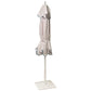 The Montecito Hex Umbrella stands upright on a white base, featuring light-colored fabric and dark trim—an elegant showcase of Santa Barbara’s refined style.