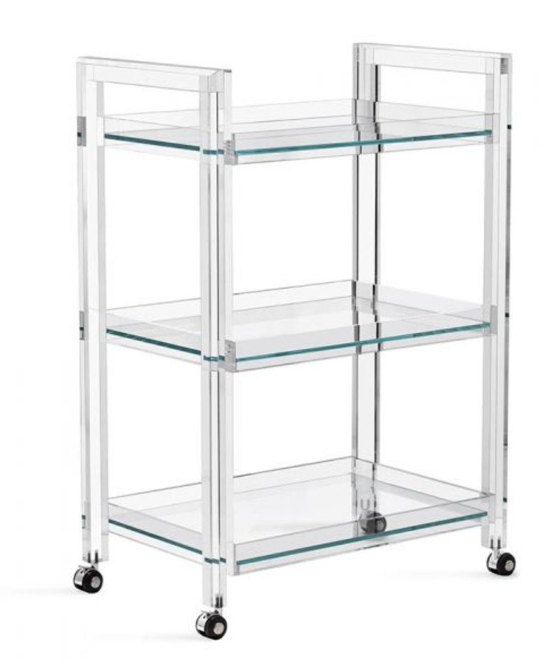 The Ava Acrylic Bar Cart boasts a clear acrylic and glass three-tier rectangular design with four caster wheels, shown on a white background.