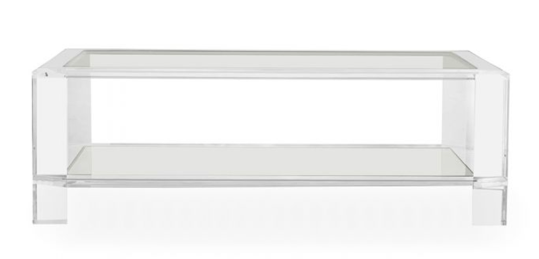 The Surrey Acrylic Rectangular Cocktail Table features a clear acrylic frame, rectangular glass top, and lower glass shelf, bringing a modern accent to your contemporary living space. Shown against a white background.