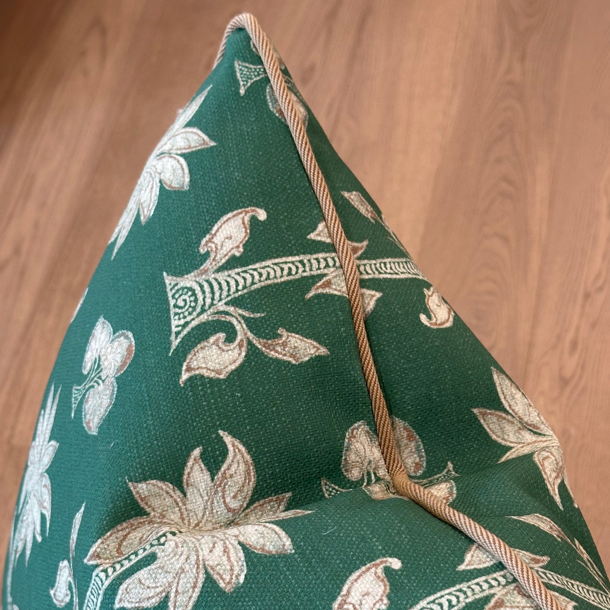 The Mazari Palm Outdoor Pillow features a green cushion with beige floral patterns and tan piping, made from weather-resistant fabric—ideal for enhancing your outdoor space.
