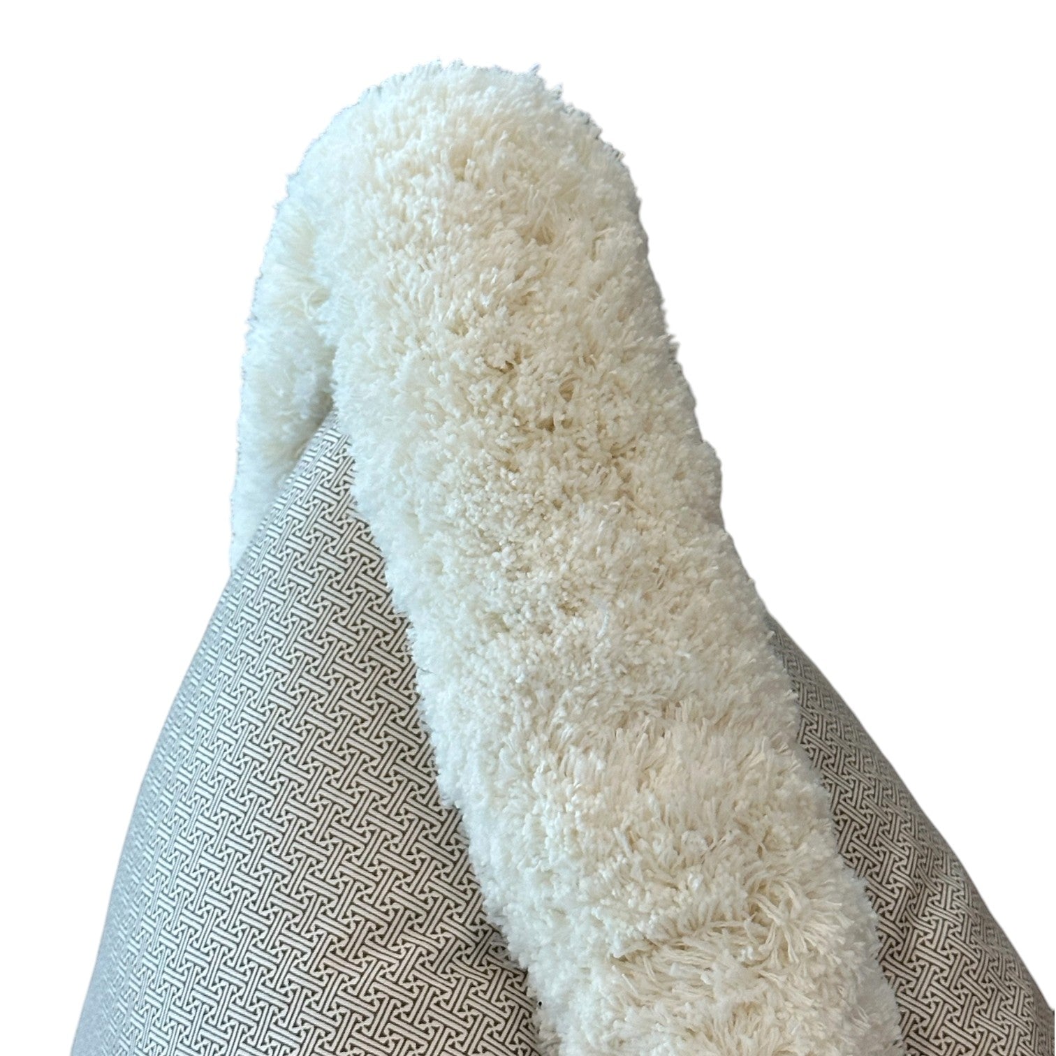 A close-up of the Lattice Cocoa Pillow, featuring a geometric patterned fabric in white with a fluffy cream trim, crafted from premium materials against a white background.
