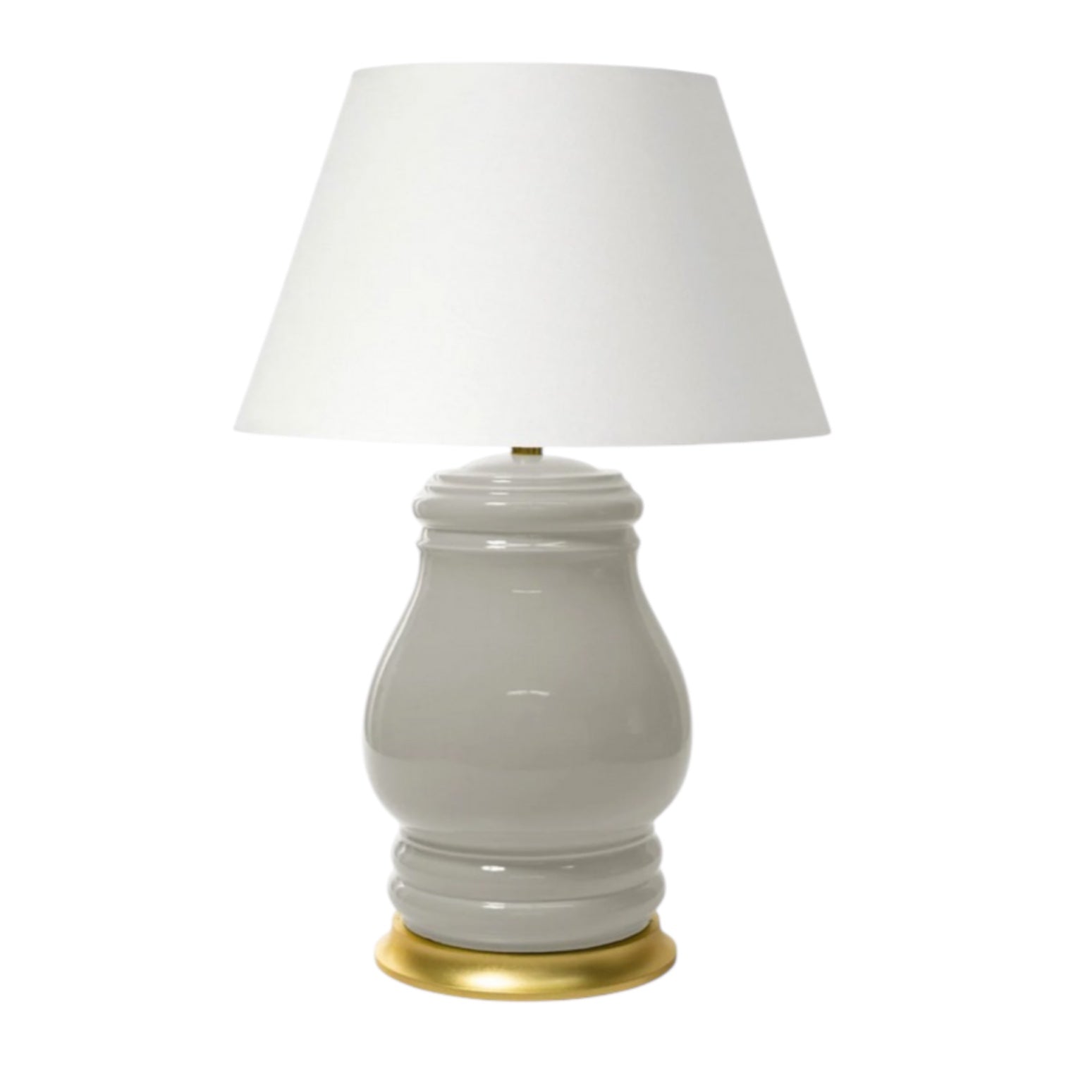 The Charleston Table Lamp in Greige showcases a glossy, curvy ceramic base with a gold-toned rim and a wide white fabric shade, creating an elegant look that adds a cozy ambiance to any room.