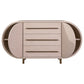 The Mullinex Low Cabinet features an oval shape, modern design, three central drawers, two curved side doors, brass legs, and a light wood finish.