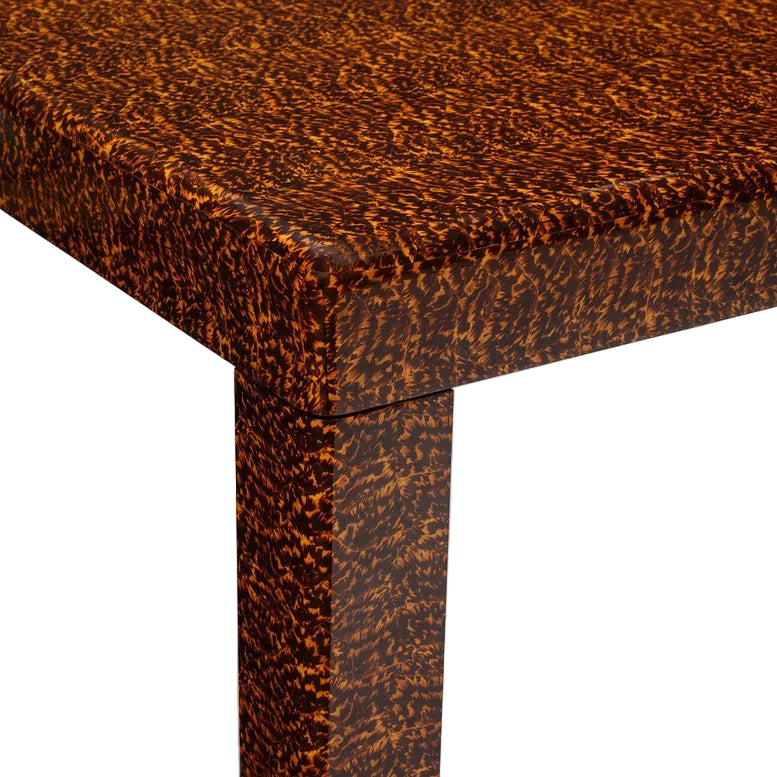 Close-up of the Bradford Coffee Table corner, featuring a brown and orange mottled faux tortoise shell pattern on both tabletop and leg, bringing unique style to your home decor.