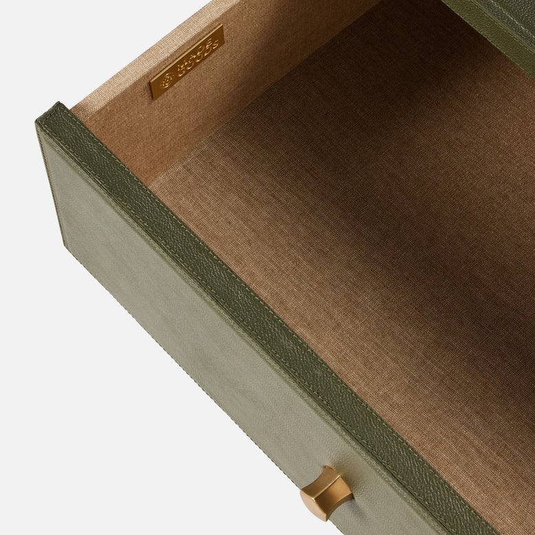 The Conner Dresser features an empty drawer with a green exterior, beige fabric interior, contrast stitching, and gold handle and nameplate.
