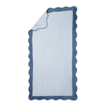 The Neptune Pool Towel is a rectangular light blue absorbent towel with a darker blue scalloped border, displayed flat with one corner folded over.