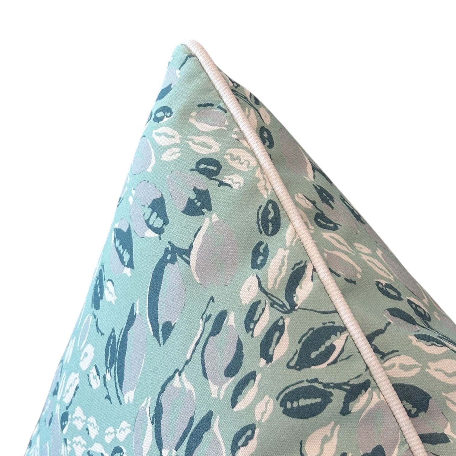 Close-up of the Cowrie Shell Aqua Outdoor Pillow, showcasing its blue and white abstract leaf design and crisp white piping, crafted with care and displayed against a clean white background.