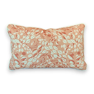 Cowrie Shell Outdoor Coral Lumbar Pillow featuring a peach background with white and coral leaf patterns, crafted from premium materials to add a touch of everyday luxury.