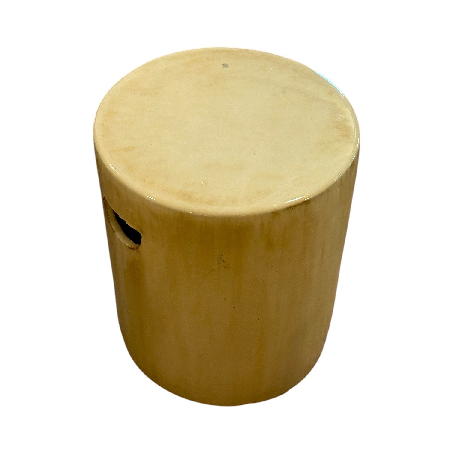 The Cylinder Stool in Latte is a round, beige ceramic piece with a smooth finish and side cutout handle, inspired by rustic dragon kiln-fired stools for an understated antique look against a white background.
