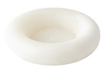 A round, white, shallow bowl made of Italian alabaster, viewed from a slight angle, exudes a sculptural elegance. The Alabaster Ring Bowl, Squat epitomizes this blend of artistry and functionality.