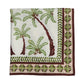 The Kim Seybert Oasis Tablecloth features a white base with printed palm trees and a brown and green decorative border, adding an island-inspired touch to your table setting.