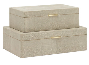 Two nested beige textured rectangular boxes with gold-colored accents, featuring a luxurious suede interior and a chic brass tab, one smaller on top of a larger one: Kiraz Sand Shagreen Box, Large.