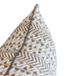 Close-up of the Luxor Coco Lumbar Pillow, showcasing its decorative white background with brown geometric patterns and subtle gray piping along the edge. This custom-made pillow features a hidden zipper closure for a seamless appearance and easy removal.