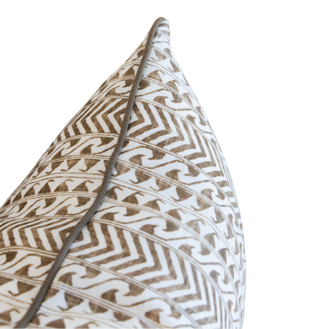 Close-up of the Luxor Coco Lumbar Pillow, showcasing its decorative white background with brown geometric patterns and subtle gray piping along the edge. This custom-made pillow features a hidden zipper closure for a seamless appearance and easy removal.