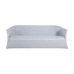 The Bari Sofa in Chambray is a light blue and white striped outdoor sofa with water-resistant cushions, curved arms, a skirted base, and is shown from the front.