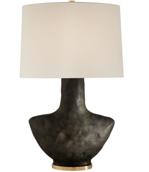 The Armato Small Table Lamp, Stained Black Metallic features a textured black ceramic base, a cylindrical white lampshade, and a small gold accent at the base, adding an artistic touch to any room.