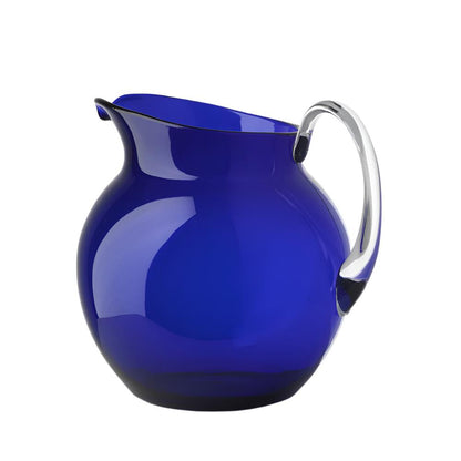 The Mario Luca Giusti Acrylic Palla Pitcher Collection showcases a clear, curved blue pitcher with a transparent handle, exuding modern antique charm against a white background.