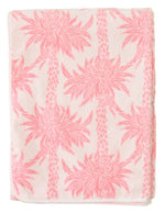 The Weezie Towels x Meg Braff Pool Lounge Cover features a pink pattern with palm trees on a light background, capturing Palm Beach elegance.