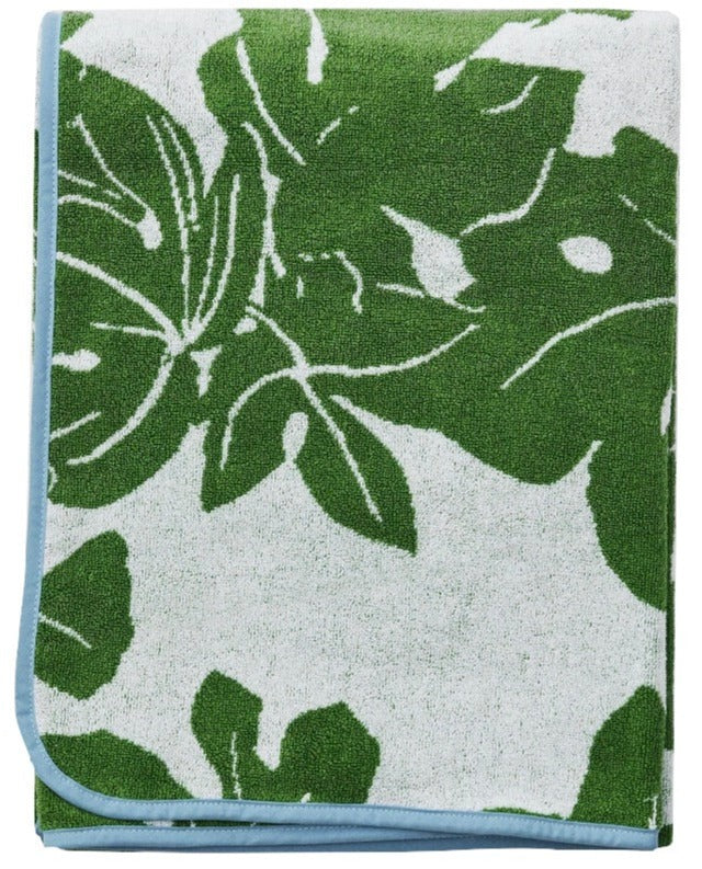 Indulge in the sophistication of the Weezie x Peter Dunham Fig Beach Towel, featuring a folded design in a vibrant green and white leaf pattern, accented with a chic blue border. Generously sized for ultimate comfort by the sea.