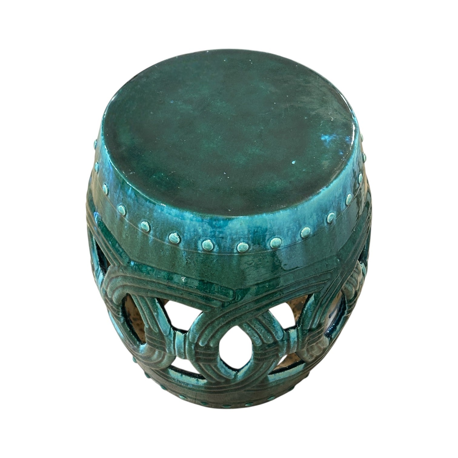 The Circle Garden Stool in Green and Turquoise features a round ceramic design with decorative cut-outs and a solid top, inspired by rustic styles and finished for an antique look.