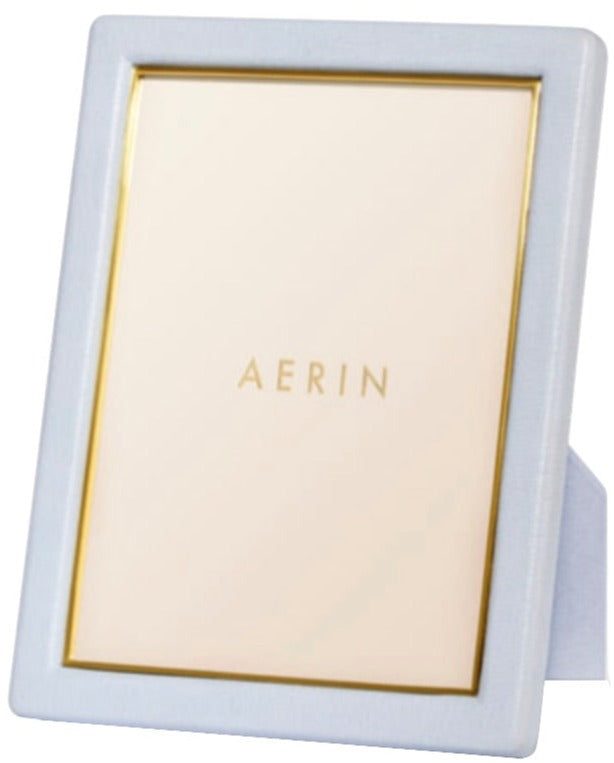 A rectangular picture frame from the AERIN Classic Piero Leather Frame Collection features a white border with gold detailing. It stands vertically with "AERIN" printed at the center, offering an elegant display for your cherished memories.