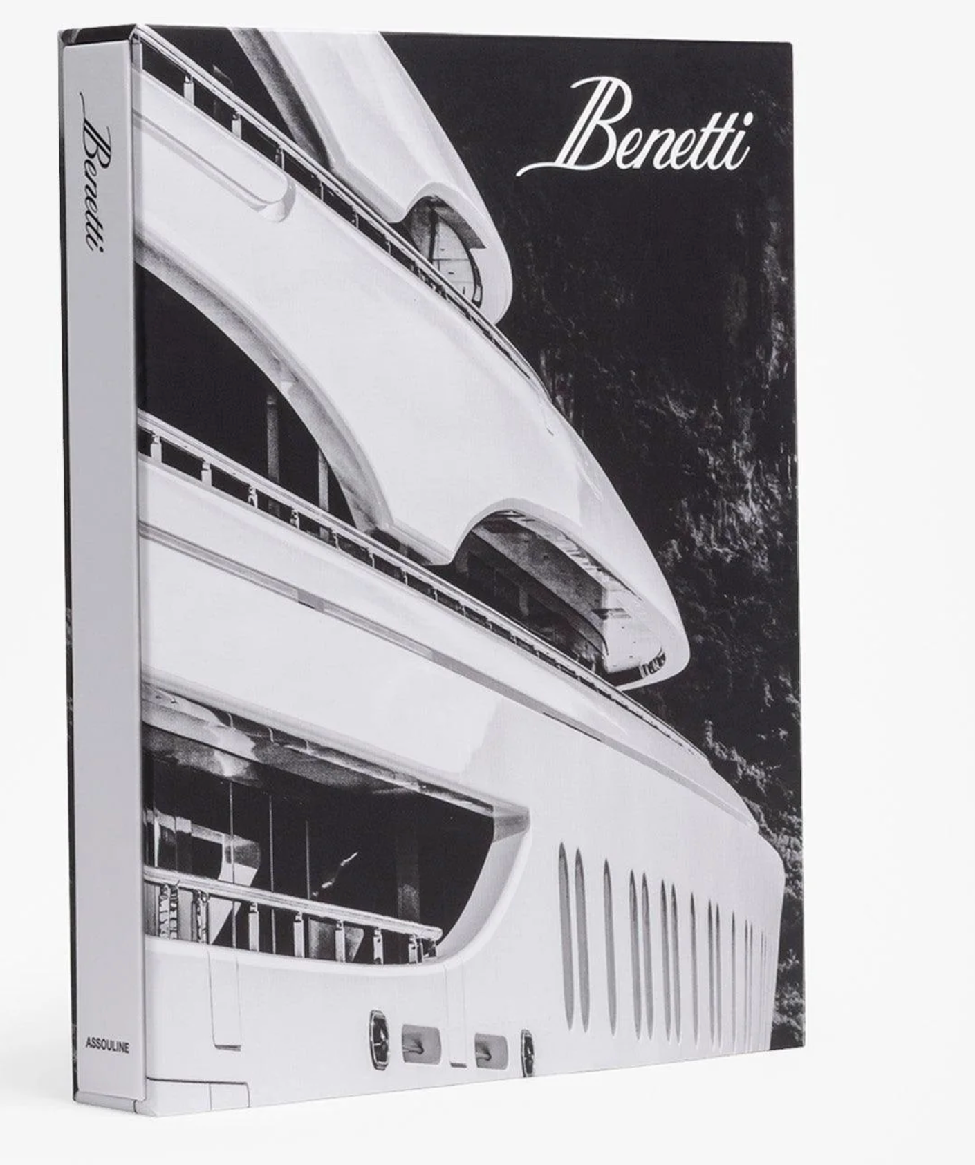 A hardcover book titled "Benetti Yachts," featuring a black and white yacht photograph on the cover, celebrates Italian craftsmanship and Benetti’s excellence, published by Assouline.