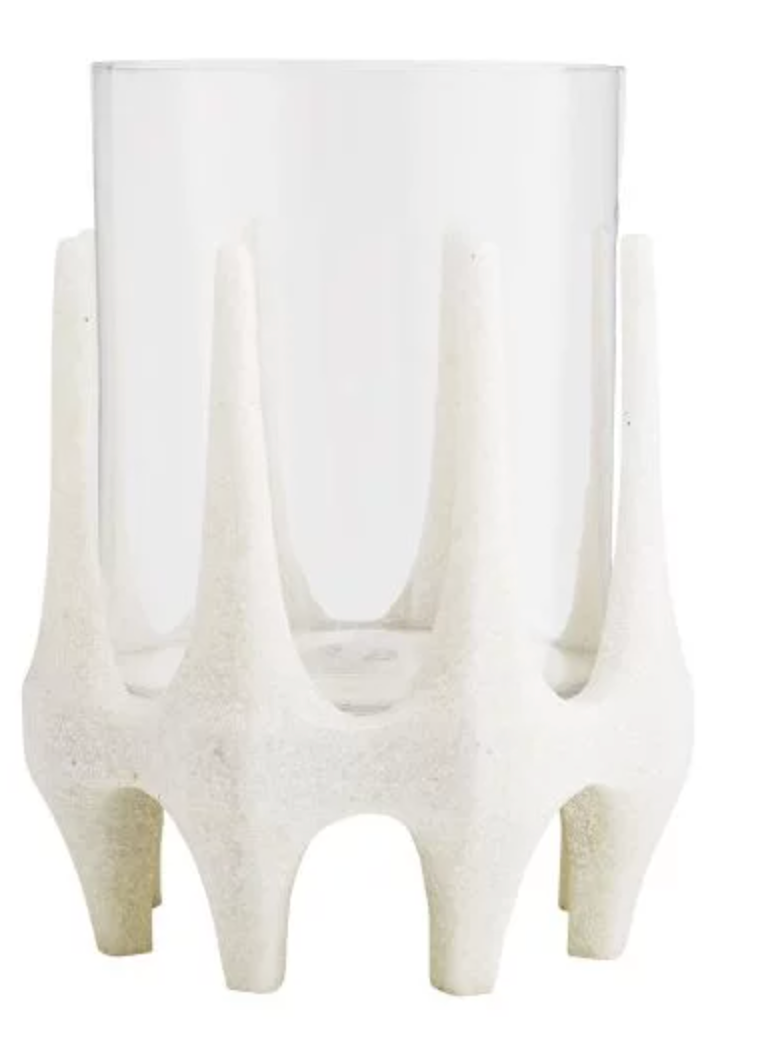 The Harmon Hurricane features a clear cylindrical glass vase nestled in a white textured holder with upward-pointing, evenly spaced prongs, showcasing subtle Brutalist style.