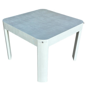 The Custom Textured Grasscloth Game Table is square with four thick legs, rounded corners, and a light gray finish in Marine-Grade Sea Salt Paint, shown against a white background.