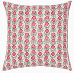The Akhil Azalea Outdoor Pillow features a white background with a repeating pattern of pink flowers and green leaves, making it the perfect weather-resistant accent to add charm to any patio or garden space.